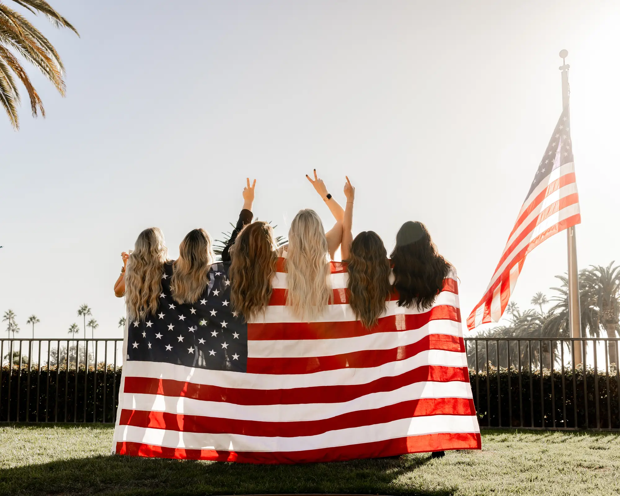The Salon Bilancio team holding an American flag on the lawn
